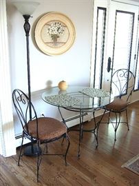 Glass top table, two chairs, floor lamp and framed print.
