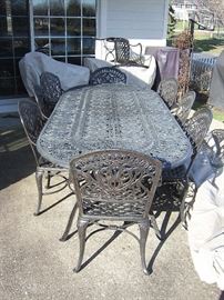Heavy duty highest quality cast iron patio table and eight chairs.