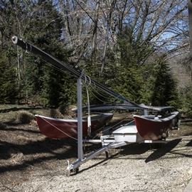 Hobie Catamaran, Trailer Hitch, and Portable Dolly: A seven-foot Hobie catamaran, trailer hitch, and portable dolly. This multi-hulled watercraft includes sail, hitch, transport dolly, and miscellaneous sailing supplies.