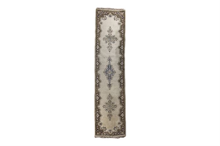 Hand-Knotted Iranian Persian Lambs Wool Carpet Runner: A hand-knotted Iranian Persian carpet runner. This rug features elongated floral medallions in shades of blue and gold against an off-white field. The straight lines of the rectilinear field are broken up by arches and points intruding into, and out of, the dark blue and gold scroll and palmette patterned border. Off-white side cords and a white fringe finish the rug. A tag is affixed to the back.