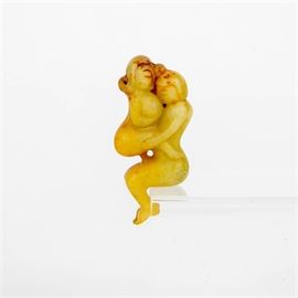 Serpentine Fertility Figurine: A serpentine fertility figurine. This figurine is made of a carved serpentine mineral. It depicts a man and a woman engaging in a sexual activity.