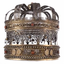 Excellent Bezalel School Sterling Silver Torah Crown: An extremely rare and important early 20th century Sefer Torah crown, made in the early days of the illustrious Bezalel School of Arts and Crafts in Jerusalem, made in between the foundation of the school in 1906 and its closing in 1929. The piece is entirely handcrafted of sterling silver (measuring 90-94% in various spots), with parcel gilding. Traditional Yemeni in form, the piece features an exquisite shape, completely formed by panels and rows of filigree work, bezel set with carnelian stones, the lowest edge set with 12 miniature, hand-carved bone medallions representing the Twelve Tribes of Israel. Bedecked with bells, a balustrade, stars of David, the piece also bears the inscription applied wording from Proverbs 3:18, “She is a Tree of Life for those who cling to it, Blessed are they who uphold her.” 
עץ־חיים היא למחזיקים בה ותמכיה מאשר
Marked on the interior with the Bezalel stamp.

The Bezalel School was established in 19
