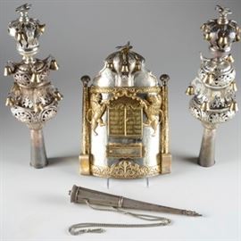 Exquisite Russian Silver Torah Set: An astonishing piece of Judaica, in the form of a nearly complete 19th-century Russian silver Sefer Torah set, comprised of a pair of rimonim, breastplate, and yad. Made in Moscow, by an unascribed maker, the set is comprised of silver, ranging in purity from 90-94%, though hallmarked as 84. Strikingly, and lovingly hand-wrought, the rimonim and breastplate are designed with parcel gilding, the rimonim with a tapered form, with layers of foliate motifs, rising to a bird finial atop each, hung all around with rows of gold plated silver bells. The breastplate, similarly designed, features the lions of Judah standing astride the עֲשֶׂרֶת הַדִבְּרוֹת, which is made of hinged doors opening to a recess. Beneath it, a slot and frame to hold interchangeable placards for different holidays. Engraved beautifully, the piece also features a long chain. The yad, of a differing design and of a lower quality silver is simply designed, with a Yiddish name engraved u