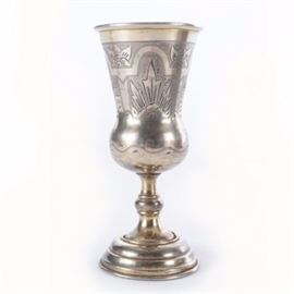 19th Century Russian Sterling Silver Kiddush Cup: A 19th century Russian sterling silver engraved footed kiddush cup. This piece has a tulip shaped cup with an etched floral and village pattern to the body and lovely round stemmed base. The rim has a partial makers mark, an “84” purity mark and a St. Petersburg city hallmark. Weighs 3.46 ozt.