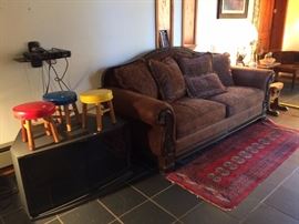 sofa, tv stand with storage below, small area rug, art