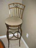 one of three brass bar stools