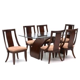 Contemporary Style Dining Table and Six Chairs: A Contemporary style dining table and six chairs, by Legacy Classic Furniture. The beveled glass top has a rectangular boat shape, having swelled sides, resting an a dark mahogany finished arched base with four chrome supports. The six gondola-form chairs, have book-matched veneered back splats.