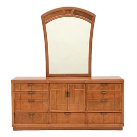 Art Deco Style Triple Dresser with Mirror: A light wood triple dresser, having a reeded frame and paneled burl veneered front, with twelve drawers, of which three are behind the two center cabinet doors. Has a matching vertical mirror with metal bracket mounts. See 17CIN104-678 through 681, for related items.