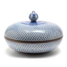 Blue and White Porcelain Chinese Covered Dish: A blue and white porcelain Chinese covered dish. A large covered dish with a “chain link” pattern with a sunburst and artichoke finial knob to the top. Both sides of the rims are covered in copper. There is a painted copper-colored strip to the foot. No marks were found on the underside.