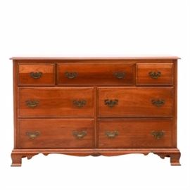 Kling Chest of Drawers in Cherry: A vintage chest of drawers by Kling Furniture, in cherry. It has seven drawers with hanging brass pulls and dovetail joints, and a shaped and carved apron. Part of a bedroom set with lots 047 and 359 of this sale.