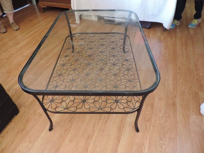 glass topped rectangular coffee table with flower decor on bottom