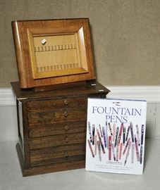 Lot 147: Wooden pen storage chest, upright pen display case and fountain pen coffee table book