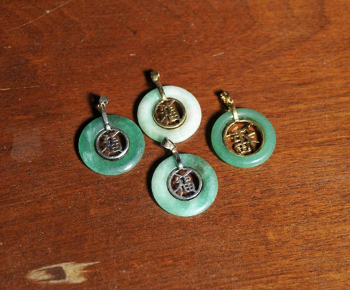 Four green round jade pendants