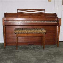 Baldwin Acrosonic Spinet Piano: A handsome vintage Baldwin Acrosonic spinet piano with a walnut cabinet, turned tapered legs, brass fittings, and a sheet music rack. The bench has a removable pad and opens to piano sheet music and instructional books. Serial number is 781923, dating to 1964.