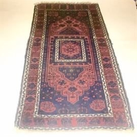 Antique Turkomen Accent Rug: An antique Turkomen throw rug. The handmade fringed rug features patterns in blue and black set on a cordovan and rusty red field. It is hand woven of wool fiber with a short flat pile. The rug’s reverse side mirrors the same pattern as the face.