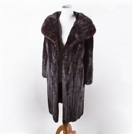 Leonard Furs Mink Fur Coat: A Leonard Furs mink fur coat. The coat features a princess collar and large textured buttons down the front. “Sybil Tash” is embroidered into the lining of the coat.