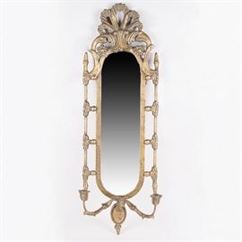 Ornate Wall Mirror with Candelabra: A wall mirror with candelabra. This antique brass tone lozenge-shaped mirror/candle sconce by Uttermost has a frame that features a decoratively carved top and sides. The bottom of the mirror frame holds three candles.