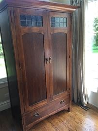 Mission style armoire wardrobe with leaded glass accents.