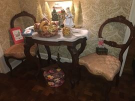 walnut turtle top marble table with two matching finger molding side chairs.