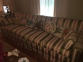 beautiful designer sofa with several needle point pillows to chose from