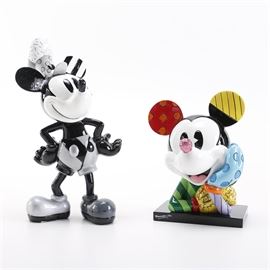 Disney Britto Figurines: A pair of Disney Britto figurines. The Britto figurines include a Mickey Mouse bust, #4033887, presented with the signature Britto patchwork appearance resting a black rectangular base with Romero Britto’s stamped signature featured at the front. Also included is a monochromatic Mickey figurine, #4039137, presenting Mickey in his Steamboat Willie appearance, standing with his hands at his waist. The figurines include their original packaging and are marked “Not a Toy for Decorative Use Only” on their underside.