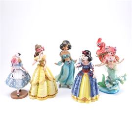 Disney Figurines Including Masquerade Snow White, Belle, and Alice: A collection of Disney figurines. This selection includes five items, featuring Belle, Alice, Jasmine, Snow White, and Ariel. Each piece is labeled by the manufacturer.