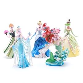 Disney Showcase Collection Figurines Featuring Princesses: An assortment of figurines from Disney’s Showcase Collection. This assortment includes five figurines featuring Disney princesses, including Tiana, Cinderella, Ariel, Elsa, and Anna. Each piece comes in its original packaging.