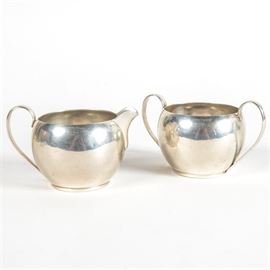 Watson Co. Sterling Silver Creamer Pitcher and Sugar Bowl: An American-made sterling silver creamer pitcher and matching sugar bowl. The set features clean, classic shapes, with rounded, unadorned sides, and graceful handles. The undersides are marked “Sterling Silver” along with maker’s marks for Watson Company of Attleboro, Massachusetts. Total approximate weight, 6.32 ozt.
