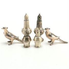 Weighted Sterling Salt and Pepper Shakers With Bird Figures: A pair of weighted sterling salt and pepper shakers with bird figures. There are six shakers in this lot with three pairs. One pair feature pierced holes to the sides with tapered and rounded bodies along with skirted bases; they have gadroon trim and are marked, “Empire Sterling Weighted 246.” The bird shakers feature perforated heads with fluted feather details and hammered-style bodies; they feature indiscernible maker’s marks. The third pair feature fluted and tiered tops with perforations to the sides with skirted bodies and rounded bases; the undersides are marked, “Sterling Weighted Duchin Creation.”
