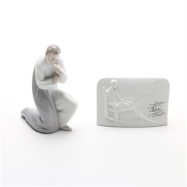 Lladró Porcelain Figures Including Saint Joseph Circa 1970: A pair of Lladró porcelain figures. Featured are two porcelain figures, one of them a kneeling Saint Joseph circa 1970. The other piece is in the form of a rectangular porcelain retail sign with a raised image of Don Quixote and the words “Lladró Collectors Society”. Both pieces are stamped to the underside “Lladro Handmade in Spain Daisa”.