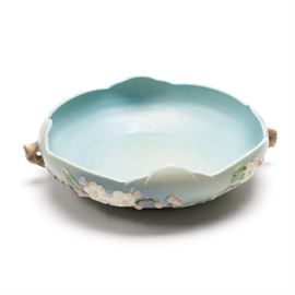 Roseville Pottery "Apple Blossom" Handled Bowl: A Roseville Pottery handled bowl. This bowl features a scalloped rim and blue surface with a Apple Blossom pattern of molded pink and white flowers, leaves, and sculpted branch-like handles on either side. The Apple Blossom pattern was introduced by Roseville in 1949. The underside of the footed base is stamped with the raised “Roseville, USA” mark and the number 330-10, which indicates the shape number and size.