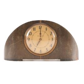 General Electric Art Deco Mantel Clock: A General Electric Art Deco mantel clock. This clock features a domed wood housing, glass panel over an off-white face, brass-tone bezel, and sweeping second hand. The clock sits on small wooden feet.