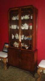 Curio cabinet filled with tea pots