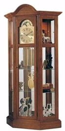 Smaller, Oak curio clock with an arched bonnet top features glass access panels allowing full view of the clock’s movement.
The lighted top section has two glass shelves as well as two adjustable shelves in the pendulum area.
A mirrored back case adds sparkle to any display.
Oak finish on select hardwoods and oak veneers compliment a polished brass finished dial with black Roman numerals and stationary astrological moon dial.
A harp pendulum with 6 1/2 inch (165mm) polished brass disk and polished brass weight shells, bring this chain driven movement with Westminster chime to life.
The front door comes with a lock for added security.
A free engraved brass plate is available with this clock.
Chain Driven Westminster Chime German Movement.