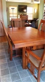 Solid Oak, Mission Style, Dining Table With 2 Leaves, pads and 6 Dining Chairs and 2 armed chairs.  Matching Sideboard and Lighted Buffet.  Table and chairs have been photographed in a 4 place setting state.  The table extends to accommodate seating for 8 when the 2 solid wood leaves and pads to protect the table.  This is a beautiful set.  