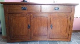 Solid Oak, Mission Style, Dining Table With 2 Leaves, pads and 6 Dining Chairs and 2 armed chairs.  Matching Sideboard and Lighted Buffet.  Table and chairs have been photographed in a 4 place setting state.  The table extends to accommodate seating for 8 when the 2 solid wood leaves and pads to protect the table.  This is a beautiful set.  