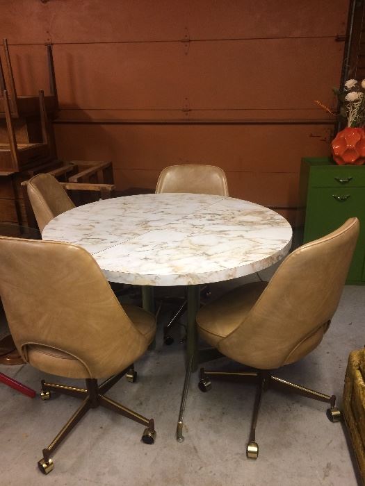 This lovely marble like table and 4 of the 6 rolling dining chairs... table comes with a matching leaf (not pictured)
