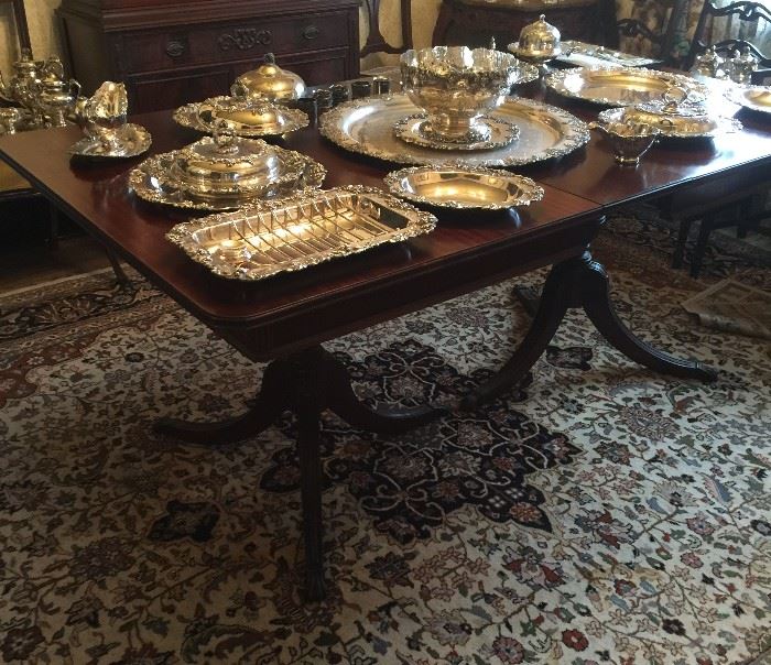 Unique pieces of the grape pattern of silver plate displayed on the Duncan Phyfe style dining room table.  The room size rug is included in the sale