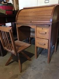 Miniature roll top desk in golden oak with swivel chair.
