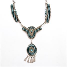 Harold Hunter Zuni Sterling Silver Needlepoint Turquoise Necklace: A sterling silver and needlepoint turquoise necklace by Zuni silversmith Harold Hunter. Features an adjustable hook clasp securing two side sections with turquoise needlepoint embellishment, leading to a center of needlepoint turquoise, with a suspended teardrop of needlepoint turquoise stones framing a center round turquoise cabochon, and five silver hanging tabs. In addition to the intricate turquoise needlepoint, Hunter uses beaded, rope and loop detailing throughout. The necklace is adjustable in length, please see measurement details for more information on size. The piece is stamped Sterling and HH and the total weight is 2.64 ozt.