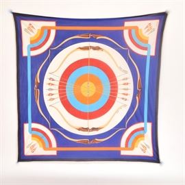Hermès "Arcs en Ciel" Silk Jersey Scarf: An Hermès silk jersey scarf in the Arcs en Ciel pattern designed by Julia Abadie. This classic pattern features an archery theme with fletches in the corners and arrows and bows surrounding a colorful target at center. The silk jersey is a lightweight, flowing, translucent fabric and it is banded in a contrasting ivory tone trim rather than rolled and hand-stitched. The blue ground is accented by white, royal, navy, scarlet, gold and tangerine. The care tags have been removed.