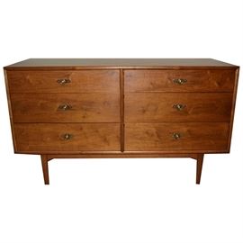 Mid Century Modern Dresser/Sideboard by Drexel: A Mid Century Modern dresser by Drexel furniture. The dresser top and frame feature a beautiful natural walnut wood grain. Dresser includes six storage drawers with brass tone knobs and sits atop four simple, rounded legs. The top drawer includes a Drexel hallmark. A companion hutch and dresser are available, items 17CIN187-043 and 17CIN187-041.