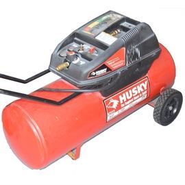 Portable 17 Gallon Air Compressor by Husky: A portable 17 gallon air compressor by Husky, model WL651004AJ. Features 120 volts, 15 amps, 60 hertz, 150 PSI max. Includes an air impact wrench.