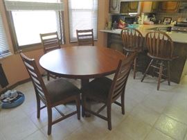 Newer nice round pedestal table and 4 chairs for dining.  Two of several stools in this house.
