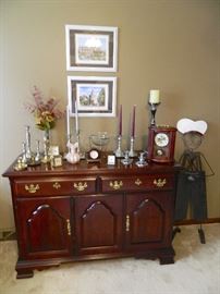 Cherry Buffet cabinet with collection of candlesticks and clocks (Howard Miller)
