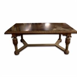 Contemporary Rectangular Dining Table in a Walnut Finish: A contemporary rectangular dining table in a walnut finish. This table features a veneer inlay top, carved edge, apron sides and scrolled pediment tops over four turned, ringed, carved, reeded legs with marble accents and bun feet. There is a stretcher at the bottom for support.