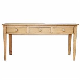 French Pine Console Table: A French Pine console table. This table features a primitive design with a rectangular top that sits on 4 square legs. It has three drawers with simple wooden pulls.