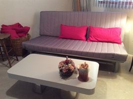 Newer futon with additional cover and pillows, laminate coffee table