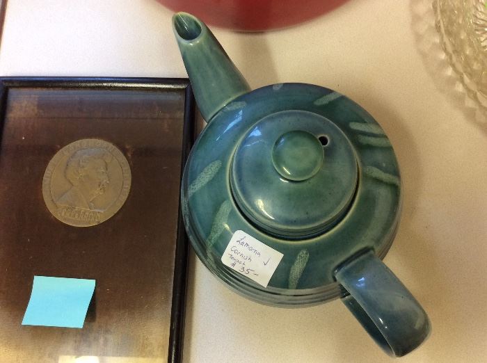 Medallion coin beside a good size Cornish teapot