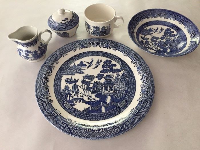 Blue willow china, large platter, 2 serving bowls 2 mugs, and cream and sugar.